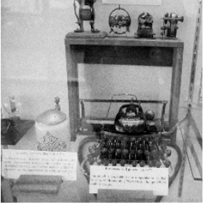 Black and white image shows historical typing equipment in a museum display.